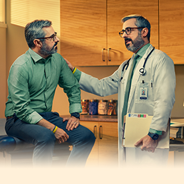 Doctor with hand on patient shoulder sitting on exam table